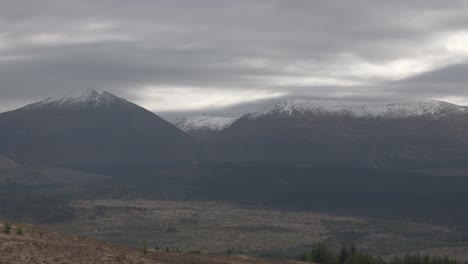 Slow-panning-shot-revealing-snow-capped-mountains-in-the-distance-of-Scotland