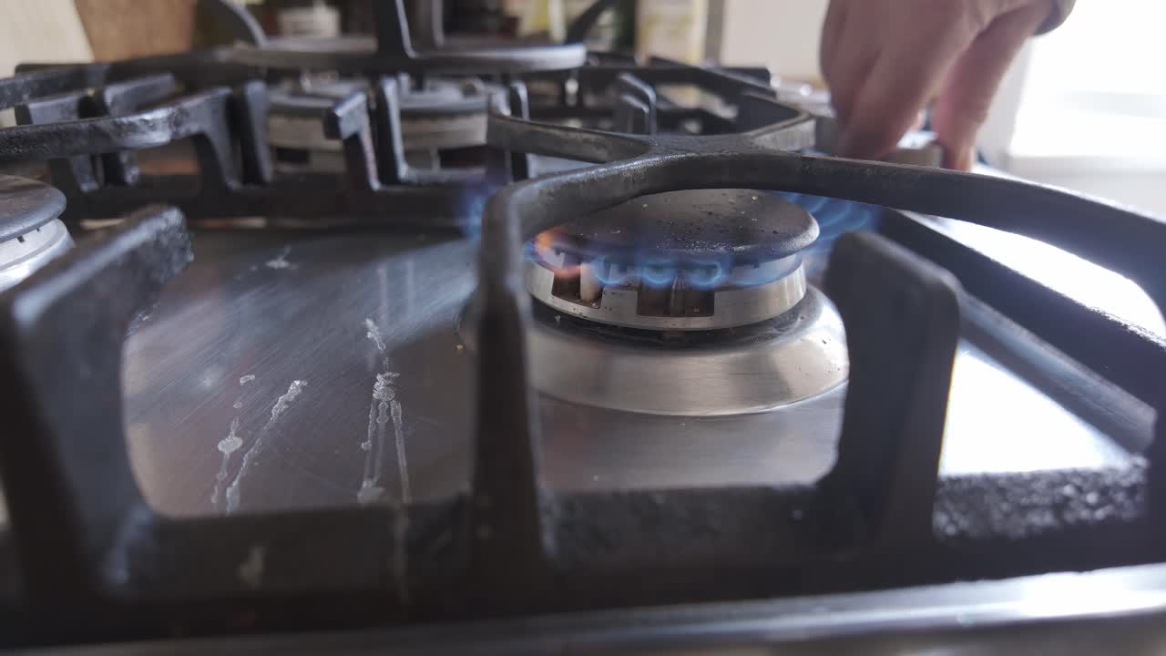 Home cook igniting kitchen gas stove appliance Medium side Shot