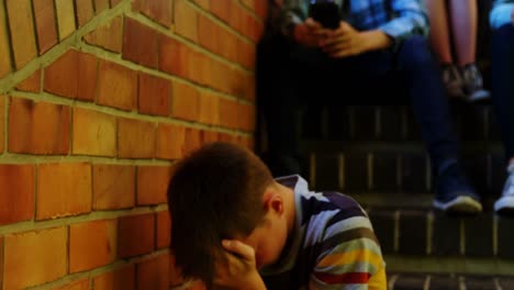 School-friends-bullying-a-sad-boy-in-school-corridor