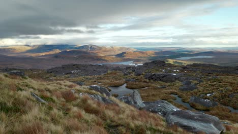 fast winds move dramatic clouds over a landscape of mountains and lochs in the north west highlands of scotland as shafts of light highlight the mountain summits