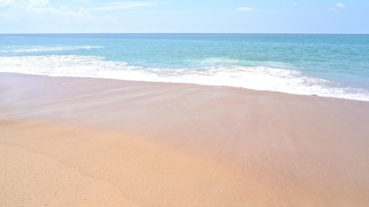 햇볕이 잘 드는 해변을 휩쓸고 지나가는 파도의 슬로우 모션