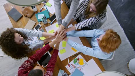 vista superior del joven equipo de negocios acurrucado en la mesa de la oficina