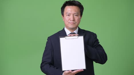 녹색 배경에 성숙한 일본 사업가