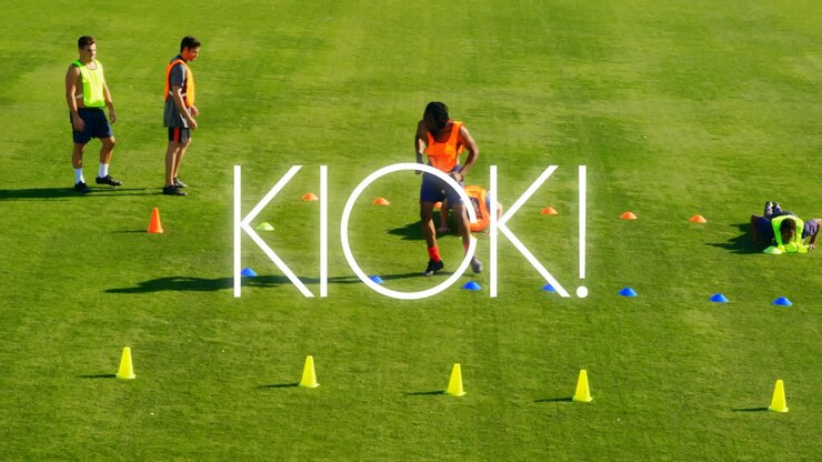 Animazione del testo "Kick" sopra giocatori di calcio sul campo