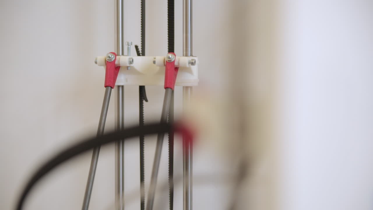close up shot 3d printer printing parts axis wires moving and working daylight