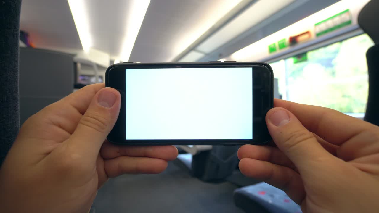 손은 기차에서  화면으로 전화를 들고 있다.