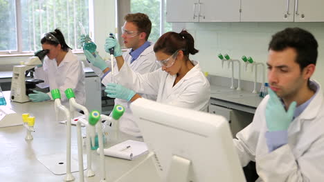 Equipo-De-Jóvenes-Estudiantes-De-Ciencias-Enfocados-Trabajando-Juntos-En-El-Laboratorio