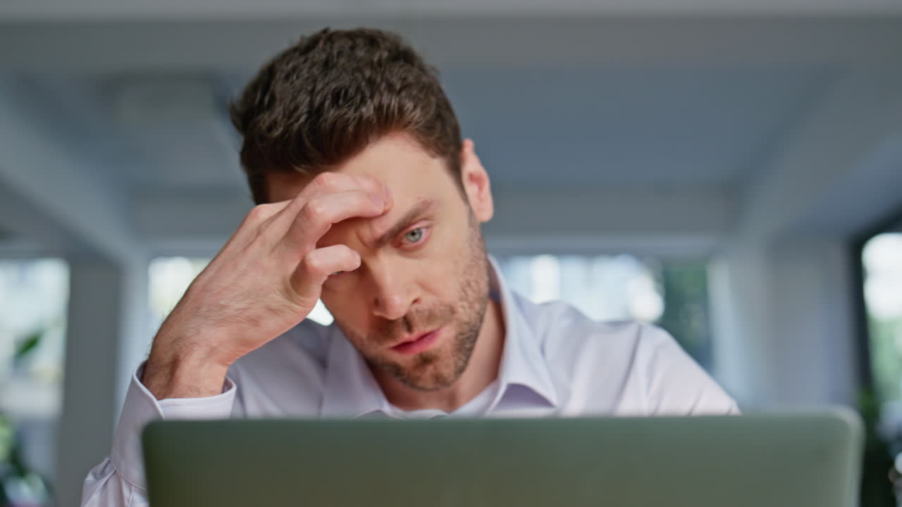 Closeup tensed freelancer working laptop at modern workplace. Frowned manager