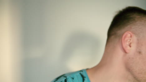 primer plano de un joven golpeándose con la mano con fuerza para que su cabeza gire hacia un lado
