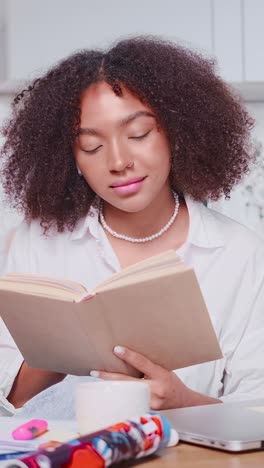 young focused positive african american woman reading book with fantasy story