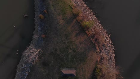 aerial drone shot looking straight down flying very high into the sky over a point of land with water surrounding