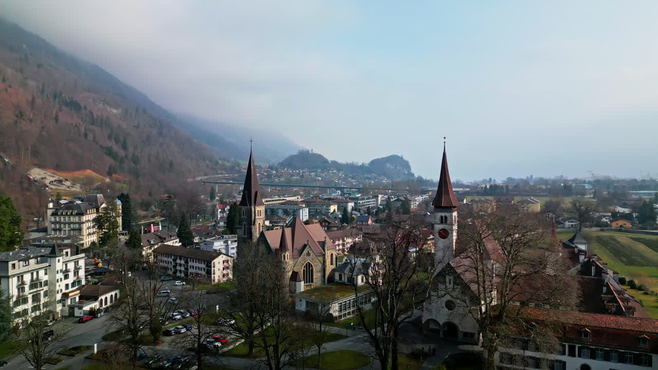 panorámica aérea sobre catedrales y capillas en interlaken, suiza, en un día nublado