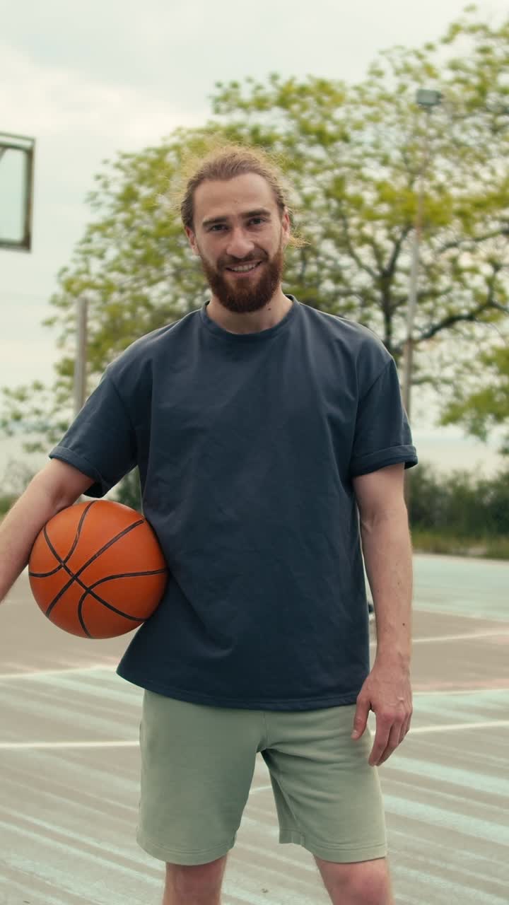 hombre sosteniendo baloncesto en la cancha al aire libre