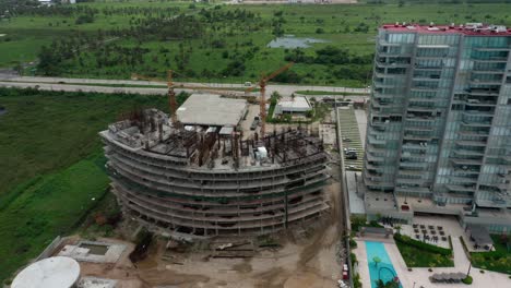 birds eye view dolly in over building under construction at day, pan shot