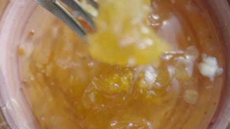 a fork dipped into a jar of honey