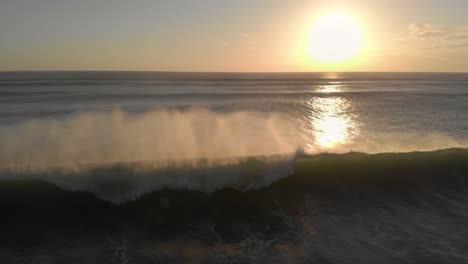 flying backwards over an ocean at sunset, following a big rolling wave
