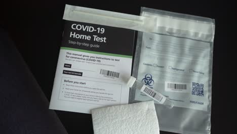 Kit-De-Prueba-Casera-De-Coronavirus-Covid-19-Con-Guía,-Tubo-De-Ensayo-Y-Punta-Q-De-Algodón-Sobre-La-Mesa