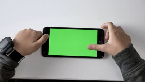 children's hands playing on a smartphone, green screen, chromakey concept, top shot 60 fps