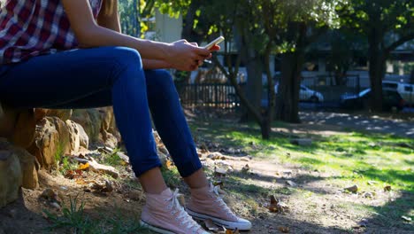 Woman-using-mobile-phone-in-the-park-4k