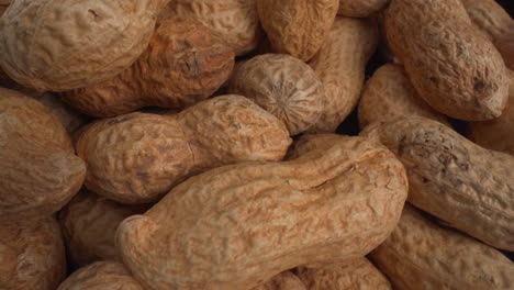 peanuts in shells macro moving, food product used in recipes like chocolates, sauces and oils, known allergen, healthy nuts, peanut allergy, 4k top shot