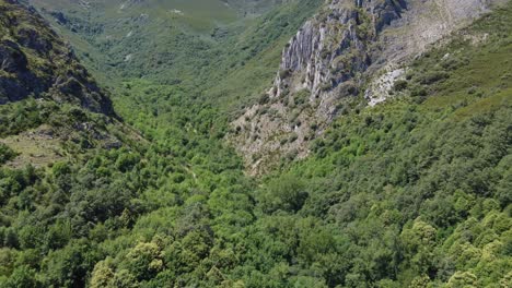 Aerial-view-flying-forward-revealing-a-hidden-valley-between-mountains