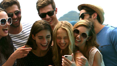 happy friends watching a smartphone