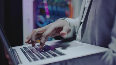 hands of it engineer using laptop in server room
