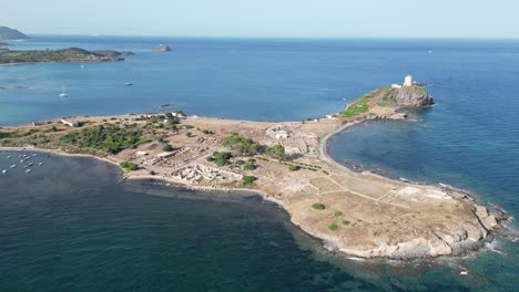 Nora-Peninsula-and-Archeological-site-with-ancient-Roman-ruins-in-Sardinia,-Italy---Aerial