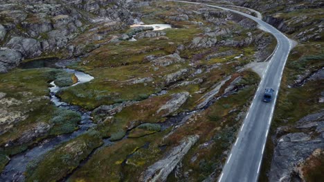 Imágenes-Aéreas-De-Una-Furgoneta-Azul-En-Una-Pequeña-Carretera-En-Noruega