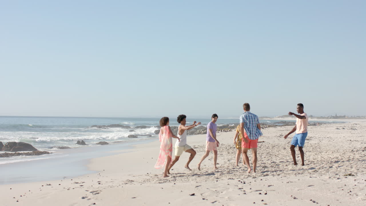 다양한 친구 들 이 빛 이 있는 해변 에서 축구 를 즐기고, 복사 공간 이 있다