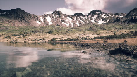 un lago de montaña sereno con un reflejo de los picos circundantes