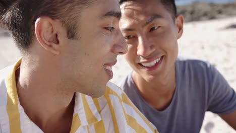 happy diverse gay male couple embracing at beach, slow motion