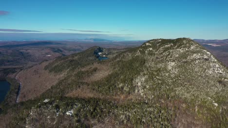 aerial pullback while descending of snow dusted mountain in maine