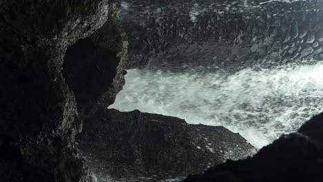 disparo vertical en cámara lenta de grandes rocas de una gran cascada en gianyar bandung con vistas al agua que fluye durante un viaje de verano a bali indonesia en cámara lenta