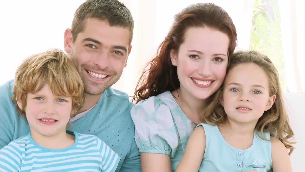 Familie sidder på en sofa derhjemme
