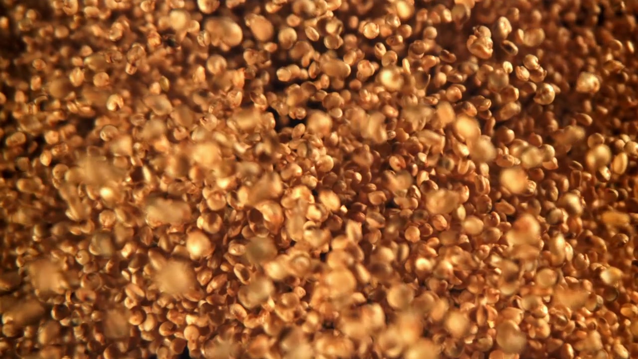 Semi di quinoa dorati che cadono al rallentatore
