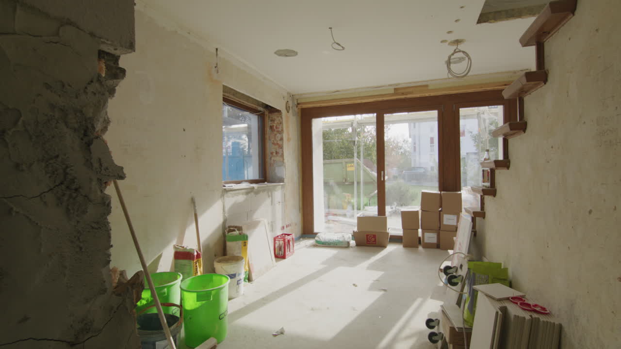 Breedbeeld van een bouwplaats in een Duits eengezinshuis, veel gereedschap en tassen op de grond