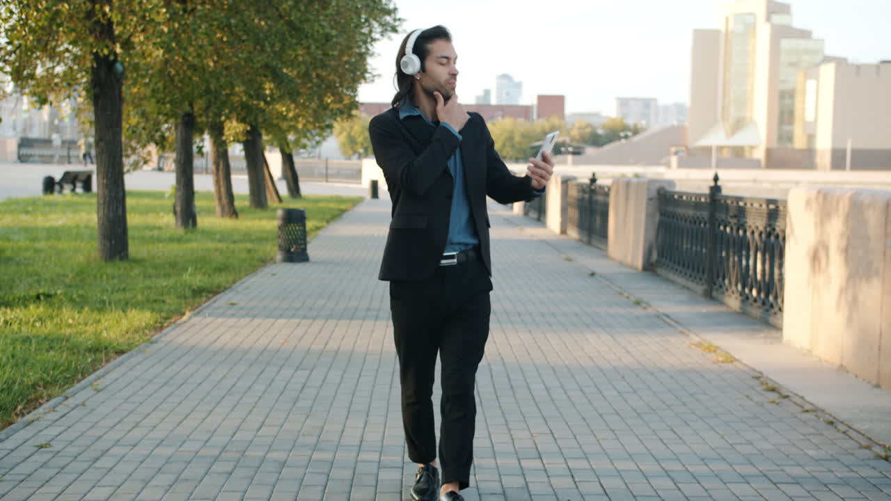 Man enjoying music and video call while walking in the park