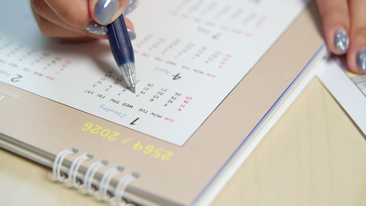 A focused individual meticulously organizes their tasks using a calendar showcasing effective time management