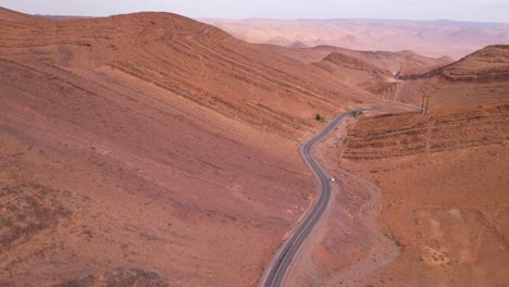 Aerial-backwards-flight-along-asphalt-road-of-Atlas-Mountains-Agadir,Morocco