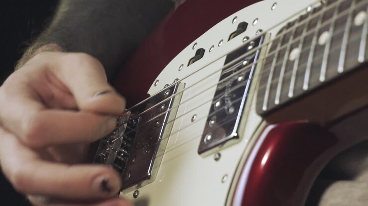 Mani con smalto nero sbeccato che suonano la chitarra