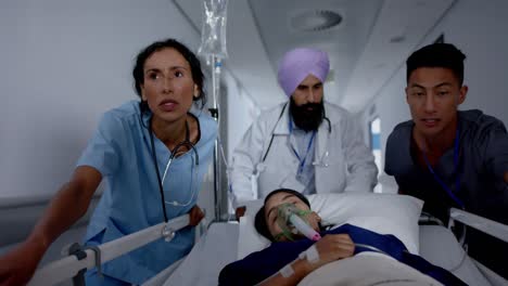 Busy-diverse-doctor-and-surgeons-talking-and-walking-with-patient-on-hospital-bed-in-slow-motion