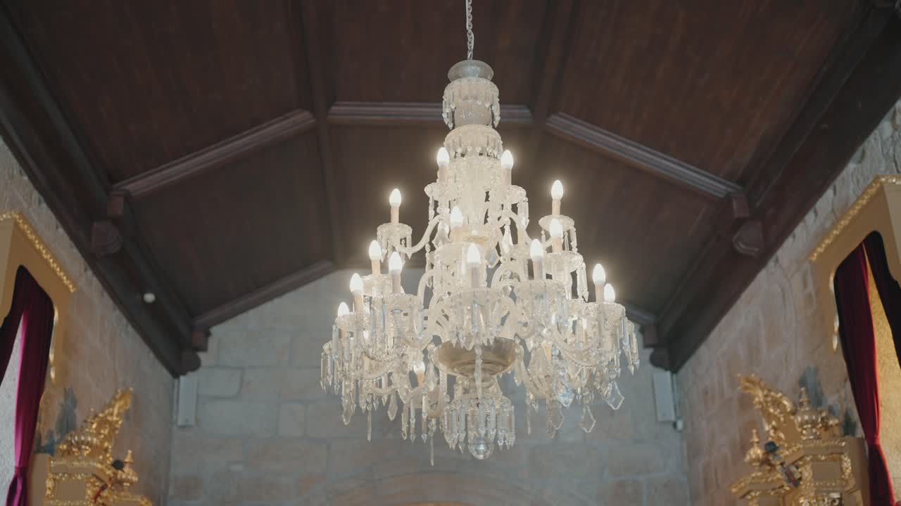 Elegant crystal chandelier illuminating a warm and ornate interior space
