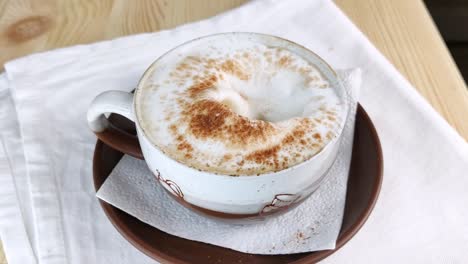 Cappuccino or latte. Spoon scoops milk froth from cup of coffee