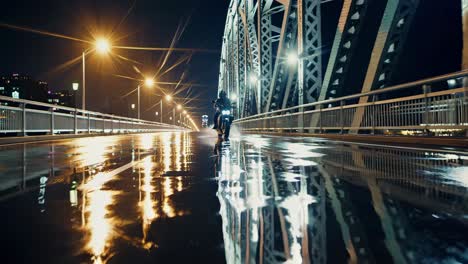 motorcyclist on a rainy night bridge