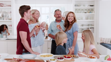 Familia-Y-Amigos-De-Varias-Generaciones-Reunidos-En-La-Cocina-Para-La-Fiesta-De-Celebración