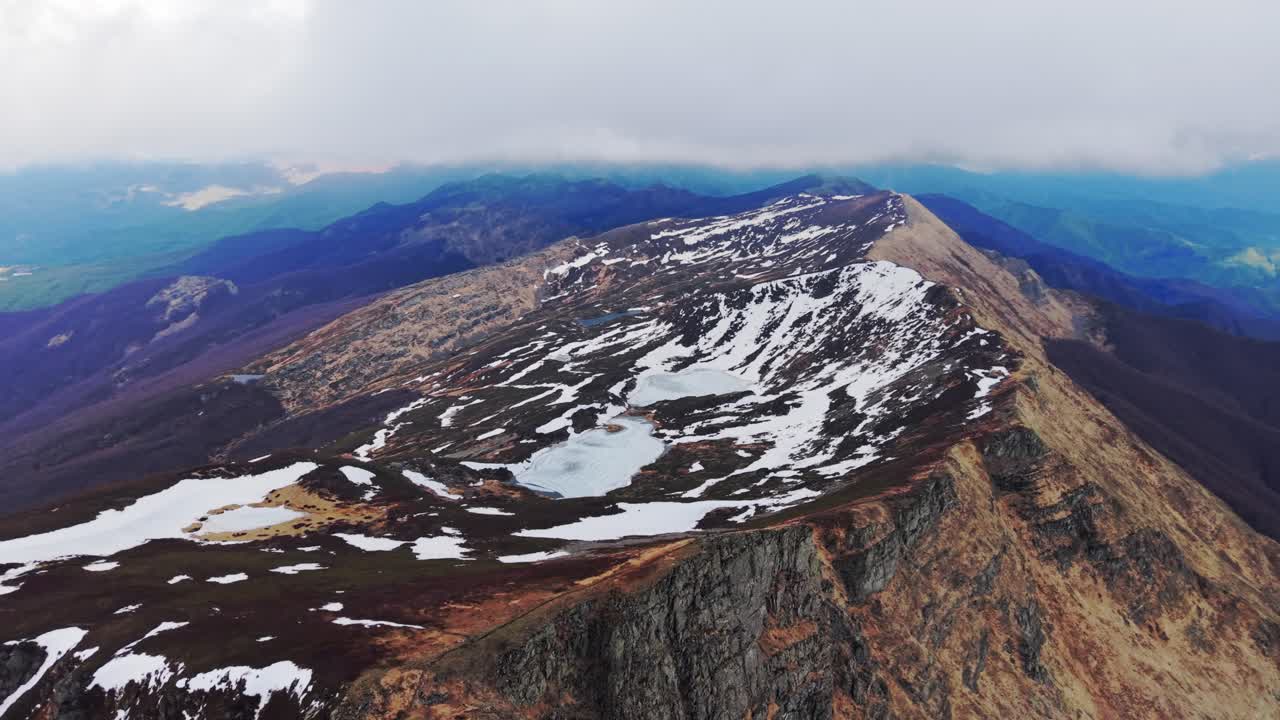 Snow-capped peaks of the Dolomites Mountains surrounded by lush green slopes