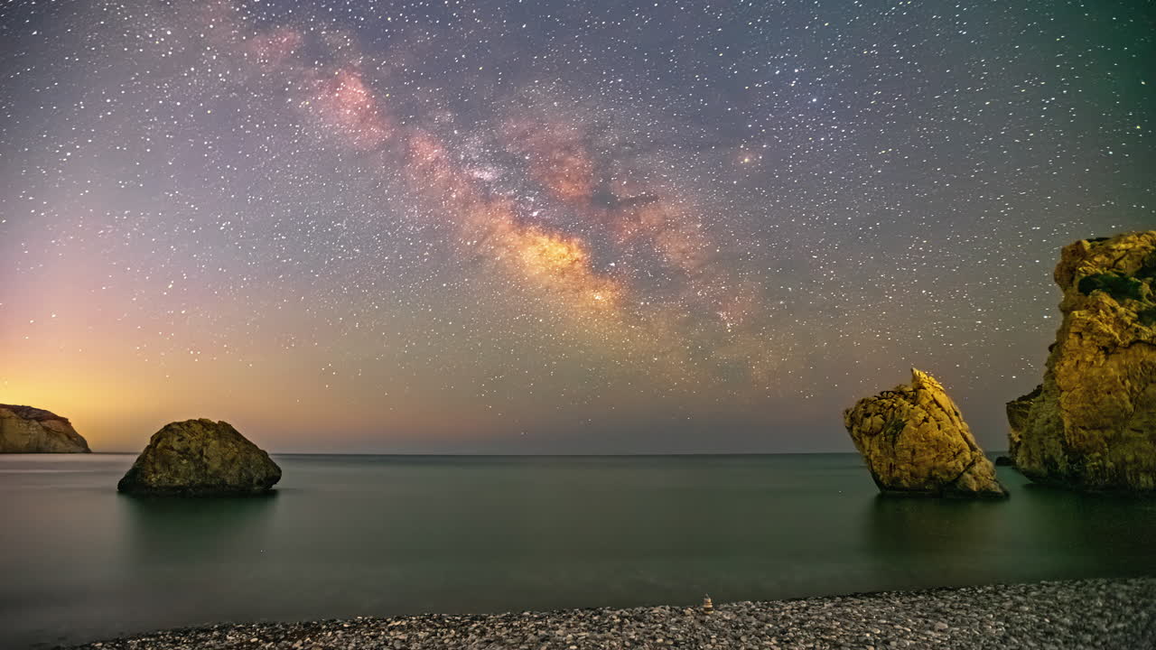 A purple starry sky with milky way passes Aphrodite's Rock Viewpoint on Cyprus