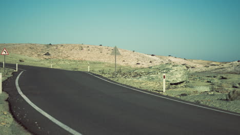 curved road leading through the arid landscape of mongolia under blue sky