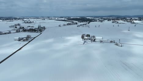 drone high angle showing snowy winter scenery with farmstead